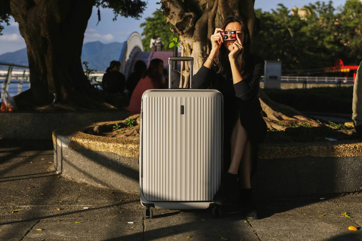 Influencer posing with Insta-worthy luggage in airport instagram pics near window light